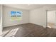 Open concept living room with a large window offering natural light and wood-look floors at 195 Hawksmoore Ln, Lillington, NC 27546