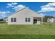 The back of the house with two windows and sliding glass doors overlook the spacious backyard at 195 Hawksmoore Ln, Lillington, NC 27546