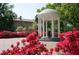 The Old Well landmark is surrounded by pink flowers and lush greenery on a sunny day at 2011 Trident Maple Ln, Chapel Hill, NC 27517
