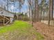 Large backyard with mature trees and a glimpse of the deck, offering plenty of space for recreation at 204 Sugarland Dr, Apex, NC 27502