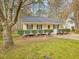 Charming single-story home with yellow siding, green shutters, and a cozy front porch at 204 Sugarland Dr, Apex, NC 27502