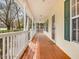 Spacious front porch with stained wood floor and white railings, perfect for relaxing outside at 204 Sugarland Dr, Apex, NC 27502