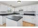 Functional kitchen featuring white cabinets, black countertops, and an island at 204 Sugarland Dr, Apex, NC 27502