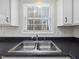 Close up on a stainless steel kitchen sink with a black countertop and natural light at 204 Sugarland Dr, Apex, NC 27502