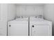 Convenient laundry room features a modern washer and dryer with shelving for organized storage at 204 Sugarland Dr, Apex, NC 27502