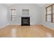 Bright living room featuring hardwood floors and a cozy fireplace with a black hearth at 204 Sugarland Dr, Apex, NC 27502