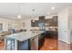 Kitchen view featuring granite counters, dark cabinets, stainless steel appliances, and an open layout at 2418 Pecan Ridge Way, Apex, NC 27502