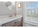 Bathroom featuring a wooden vanity with modern fixtures and a large window providing lots of natural light at 256 Marilyn Cir, Cary, NC 27513
