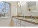Double vanity bathroom featuring natural light and granite countertops, with a neutral color palette at 256 Marilyn Cir, Cary, NC 27513