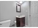 This bathroom features a toilet, vanity with sink, framed mirror, and closed door at 256 Marilyn Cir, Cary, NC 27513