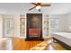 Bedroom featuring hardwood floors, a striking fireplace and hearth, built-in shelving and outside access at 256 Marilyn Cir, Cary, NC 27513
