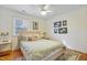 Bright bedroom featuring hardwood floors, ceiling fan, and patterned bedding at 256 Marilyn Cir, Cary, NC 27513