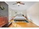 Well-lit bedroom with hardwood floors, a striking fireplace and hearth, ceiling fan, and windows at 256 Marilyn Cir, Cary, NC 27513