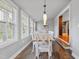 Bright dining room featuring a wood table, white chairs, modern lighting, and multiple windows for natural light at 256 Marilyn Cir, Cary, NC 27513
