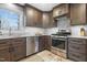 Beautiful kitchen features stainless steel appliances, dark cabinets, and tile flooring at 256 Marilyn Cir, Cary, NC 27513