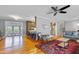 Open-concept living room featuring hardwood floors, ceiling fan, and seamless flow into the dining area and kitchen at 256 Marilyn Cir, Cary, NC 27513