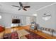 Well-lit living room with hardwood floors, ceiling fan, TV, and stylish decor at 256 Marilyn Cir, Cary, NC 27513