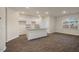 Bright, open-concept kitchen featuring white cabinets and a granite countertop island at 261 Canopy Dr, Graham, NC 27253