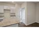 Bright kitchen with white cabinets, granite countertops, and a door leading to the outside at 261 Canopy Dr, Graham, NC 27253
