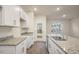 Modern kitchen featuring stainless steel sink and appliances, white cabinets, and granite countertops at 261 Canopy Dr, Graham, NC 27253
