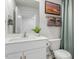 A well-lit bathroom featuring a white vanity, toilet, mirror, and decorative artwork with a mint green shower curtain at 267 Canopy Dr, Graham, NC 27253