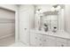 Bright bathroom with double vanity, white cabinets, and a large mirror reflecting the shower at 27 Artesa Ct, Fuquay Varina, NC 27526