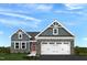 Charming two-story home featuring stone accents and a spacious two-car garage, set against a bright blue sky at 27 Artesa Ct, Fuquay Varina, NC 27526