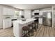 Contemporary kitchen features a center island with seating and stainless-steel appliances. Wood floor at 27 Artesa Ct, Fuquay Varina, NC 27526