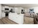 Open-concept kitchen with an island flows into a living area, stainless steel appliances, and wood flooring at 27 Artesa Ct, Fuquay Varina, NC 27526