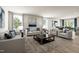 Inviting living room featuring modern sofas, neutral tones, and large windows for natural light and wood floors at 27 Artesa Ct, Fuquay Varina, NC 27526