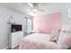 Bright bedroom with light pink accent wall, fan, and furniture at 31 Harrow Ter, Roxboro, NC 27574