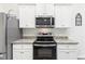 Well-appointed kitchen featuring white cabinets, granite countertops, stainless steel appliances, and modern finishes at 31 Harrow Ter, Roxboro, NC 27574