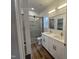 Bathroom with a double sink vanity, luxury tile shower with glass door, and wood-look flooring at 3273 Argyll Dr, Sanford, NC 27332