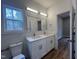 Bright bathroom with double sink vanity, modern lighting, and wood-look flooring at 3273 Argyll Dr, Sanford, NC 27332