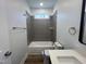 Bathroom featuring shower/tub, dark vanity with white quartz top and gray tiled shower at 3273 Argyll Dr, Sanford, NC 27332