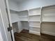 Spacious walk-in closet featuring a custom shelving system, with built-in shelving and wood-look flooring at 3273 Argyll Dr, Sanford, NC 27332
