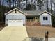 Charming single-story home boasts a two-car garage, blue siding, and a welcoming front porch at 3273 Argyll Dr, Sanford, NC 27332