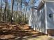 A side view of a light blue home with vinyl siding, landscaping, and wooded backdrop exudes suburban charm at 3273 Argyll Dr, Sanford, NC 27332