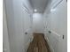 Hallway featuring wood floors, white walls, and doors on each side of the hall leading to the various rooms at 3273 Argyll Dr, Sanford, NC 27332
