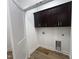 Well-lit laundry room shows wood-look flooring, upper cabinets and utility hookups for washer and dryer at 3273 Argyll Dr, Sanford, NC 27332