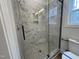 Modern bathroom shower featuring marble tile surround, pebble tile floor, and glass door at 3273 Argyll Dr, Sanford, NC 27332