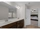 Bathroom featuring dual sinks, a white countertop, dark wood cabinetry, and a view into the primary bedroom at 3541 Fairstone Rd, Wake Forest, NC 27587