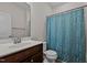 Bathroom with brown vanity, white sink and toilet, and a shower with a blue patterned shower curtain at 3541 Fairstone Rd, Wake Forest, NC 27587