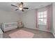 Cozy bedroom with a crib, decorative chair, plush rug, and window adorned with pink curtains at 3541 Fairstone Rd, Wake Forest, NC 27587