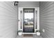 Close-up of front door with decorative plants and a 'welcome' mat, creating a warm and inviting entry at 3541 Fairstone Rd, Wake Forest, NC 27587