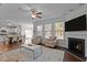 Open concept living room with fireplace, ceiling fan, lots of light, and view of the dining and kitchen area at 3541 Fairstone Rd, Wake Forest, NC 27587