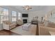 Comfortable living room with fireplace, neutral furniture, ceiling fan, and lots of light from bay windows at 3541 Fairstone Rd, Wake Forest, NC 27587