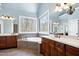 Bright bathroom with a large soaking tub, big windows, and wood cabinets at 3655 Pleasants Ridge Dr, Wake Forest, NC 27587