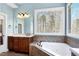 Bright bathroom featuring a soaking tub with a large window and wood cabinets at 3655 Pleasants Ridge Dr, Wake Forest, NC 27587