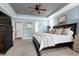 Spacious bedroom with a dark brown bed frame, blue accent walls, and a ceiling fan at 3655 Pleasants Ridge Dr, Wake Forest, NC 27587